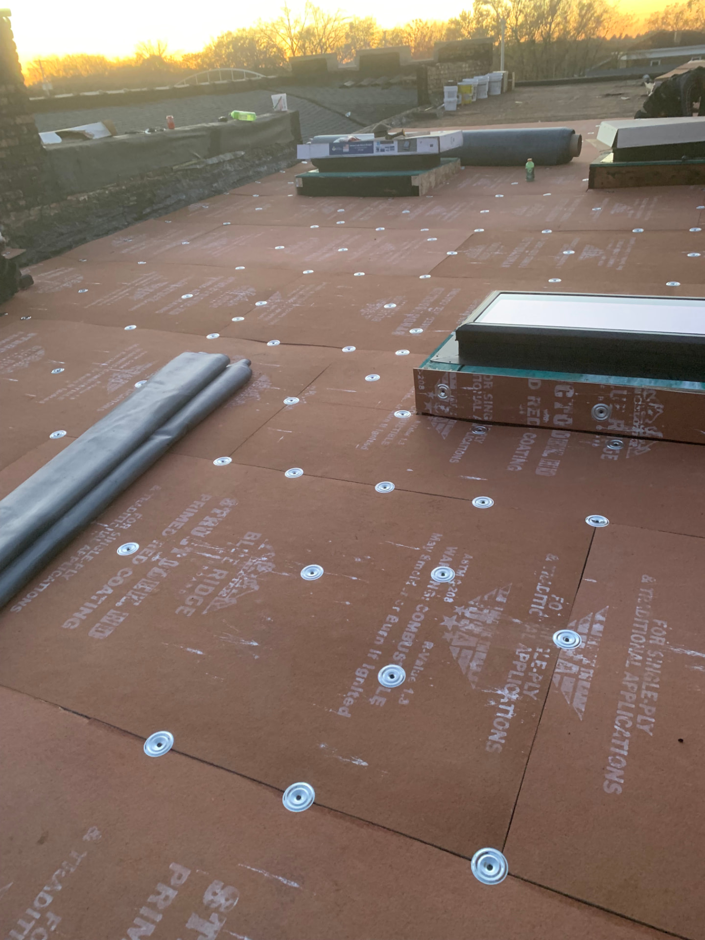 Coverboard fastened over insulation before membrane installation